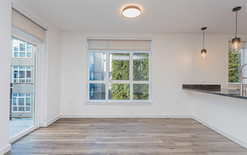 A room with a large window and a wooden floor.